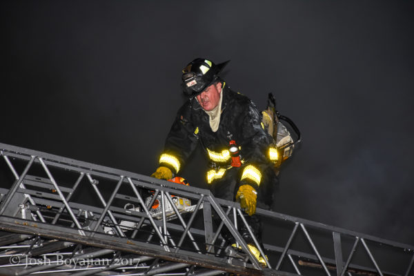 firefighter on aerial ladder at night