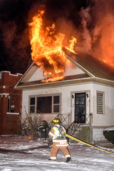 flames blowing out of house attic at night
