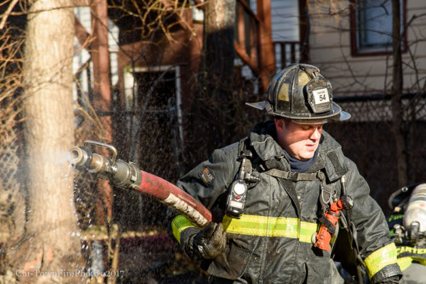 firefighter with hose line at house fire