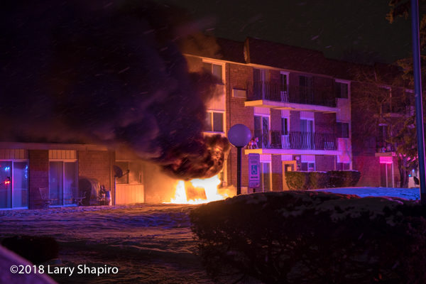 electric utility box engulfed in flames outside apartment building