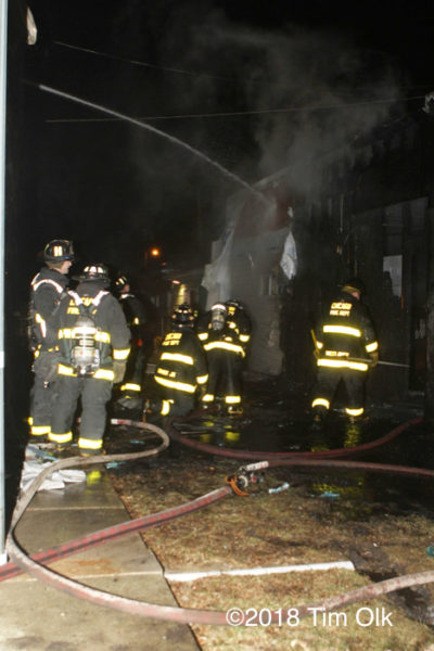 Firefighters after alley garage fire