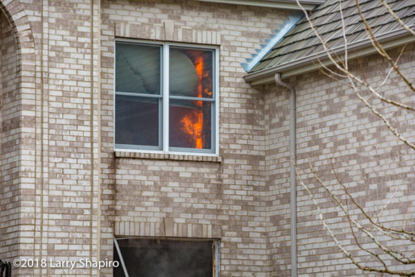 fire in the upstairs window of a house