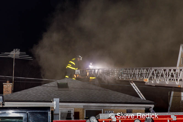 Firefighters on roof with smoke