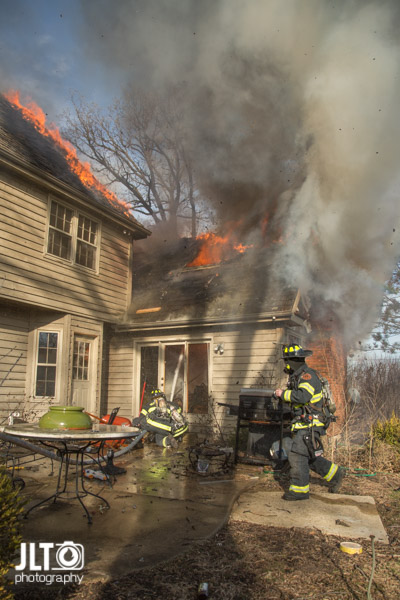 Firefighters battle house fire with flames