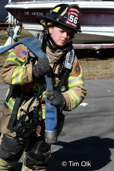 female Firefighter pulling hose