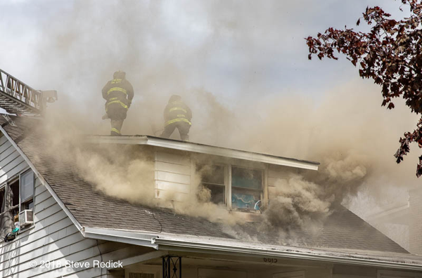 Firefighters vent house fire roof in smoke