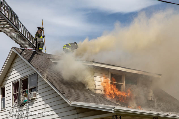 Firefighters vent house fire roof in smoke