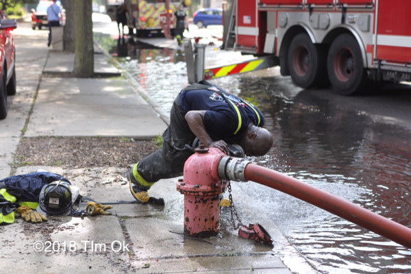 Firefighter cooling off by a hydrant