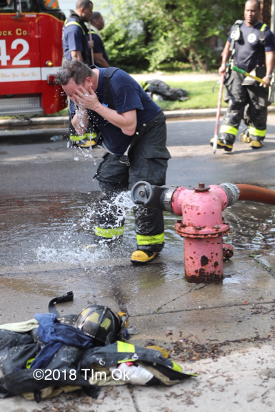 Firefighter cooling off by a hydrant