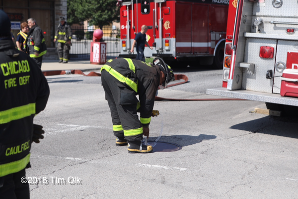 Firefighter takes gas reading in sewer