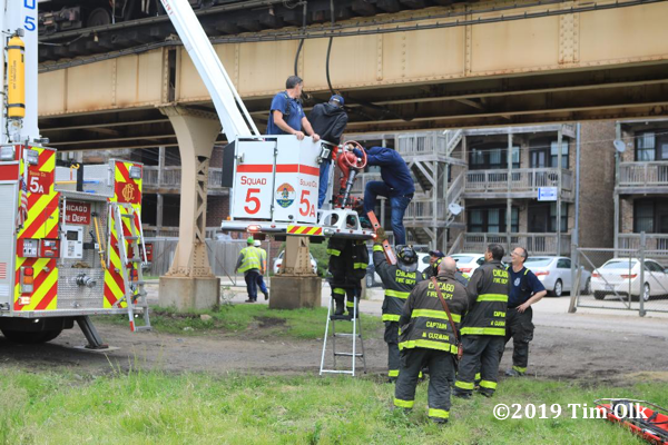 Chicago Firefighters remove civilians from an elevated train derailment