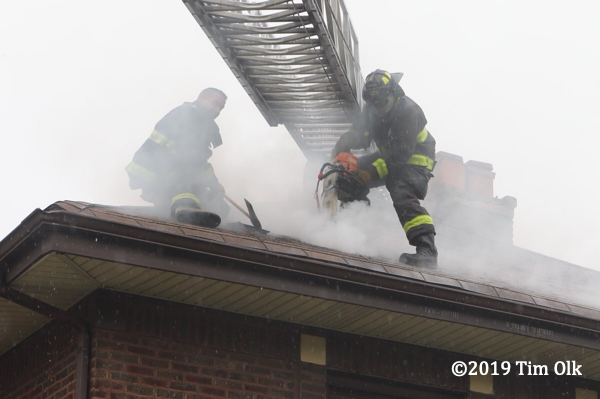 Firefighter vents roof with a saw