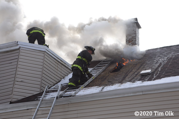 Firefighter vents roof on attic ladder for safety