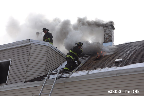 Firefighter vents roof on attic ladder for safety
