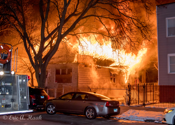 flames engulf the roof of  house at night
