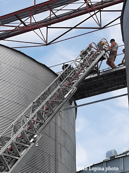 aerial ladder stretches to grain bin