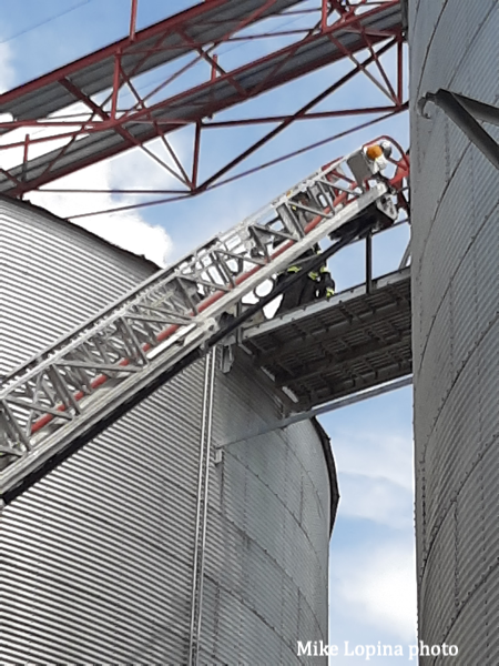 aerial ladder stretches to grain bin