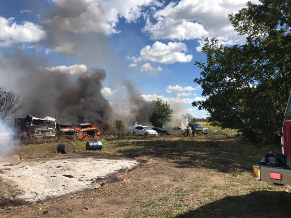 multiple cars on fire in a field