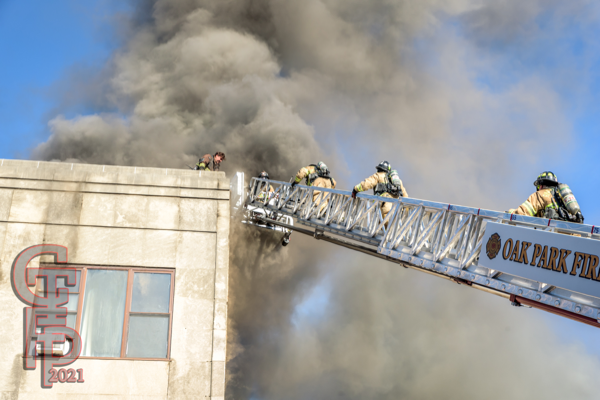 Firefighters climb E-ONE tower ladder immersed in heavy smoke